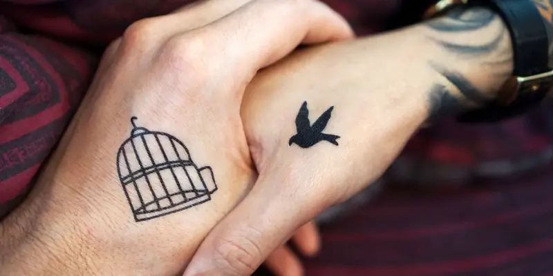 Mani di donna e uomo con piccoli tatuaggi