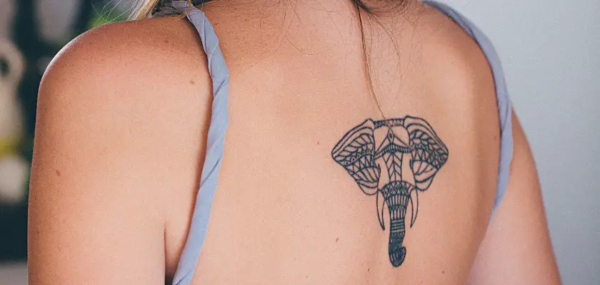 Ragazza con tatuaggio a elefante sulla spalla