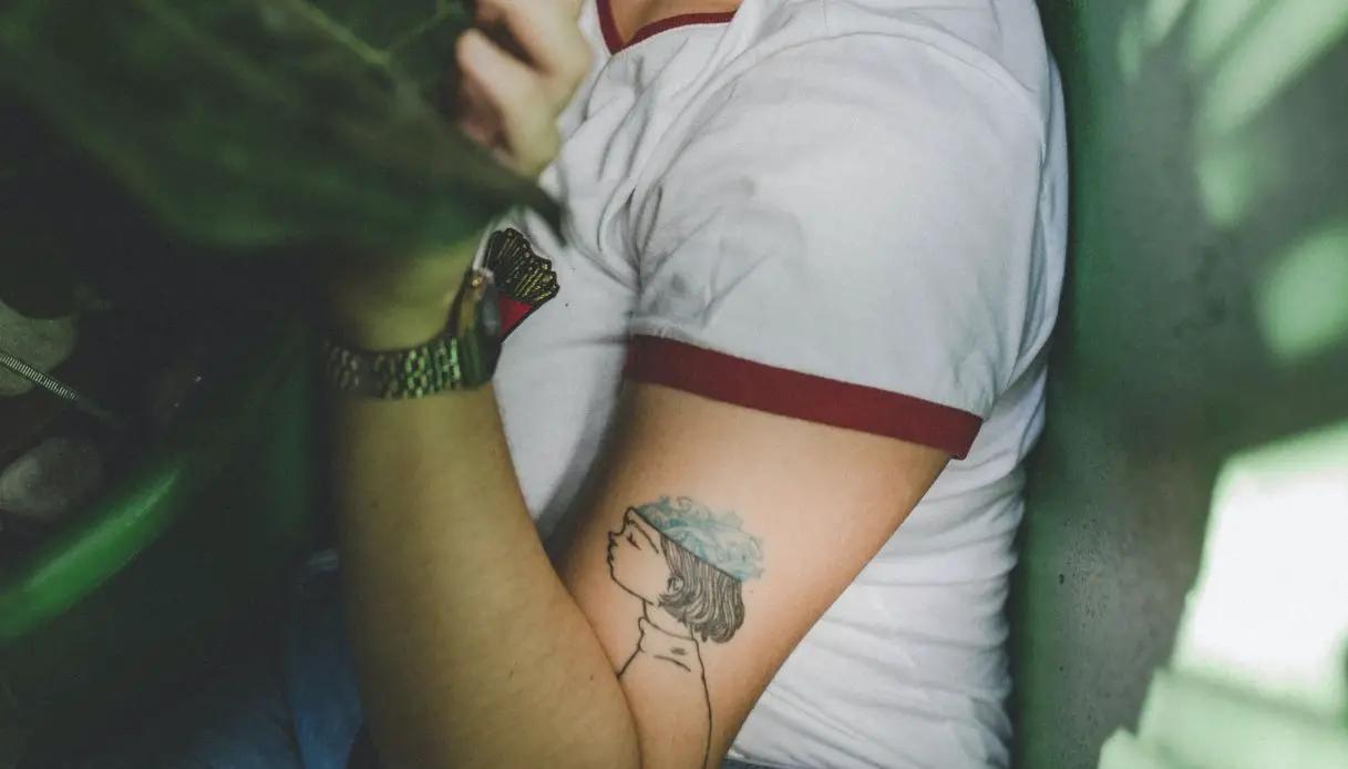 giovane donna con tatuaggio per nonni sul braccio