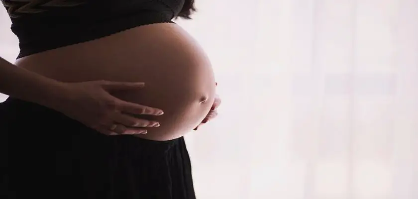 Donna incinta che mostra la sua pancia gonfia – Tatuaggi in Gravidanza