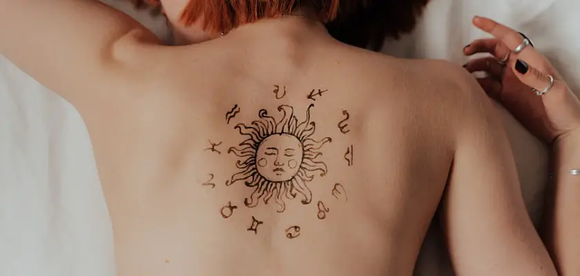 Ragazza con un tatuaggio sole sulla schiena