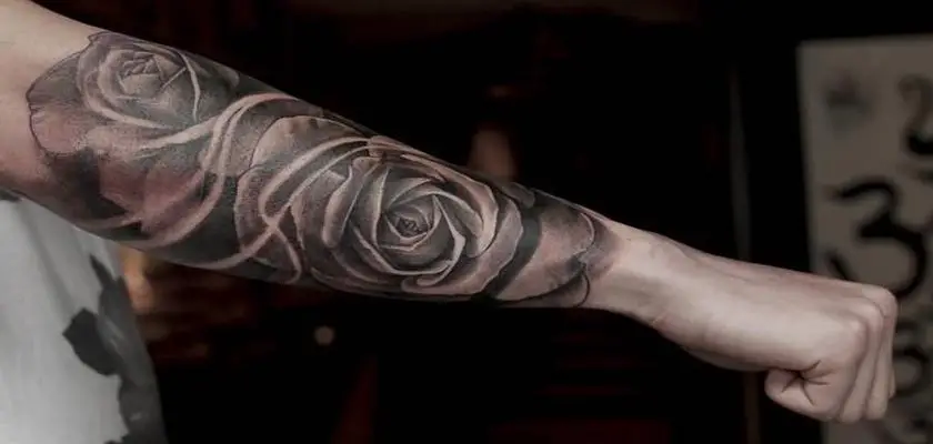 Ragazzo che mostra il suo braccio destro con un grande tatuaggio a fiore