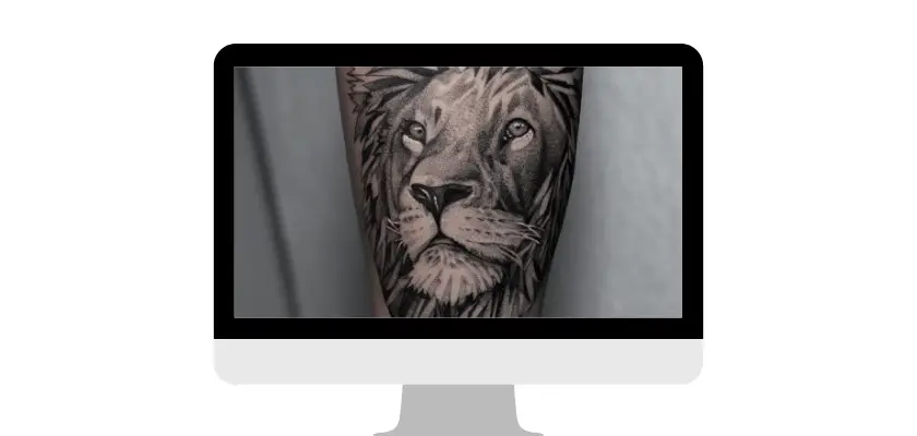 Immagine di un braccio destro con un tatuaggio leone vista dal monitor del desktop