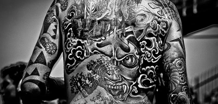 Vista parziale posteriore di un uomo con un grande tatuaggio chicano sulla spalla